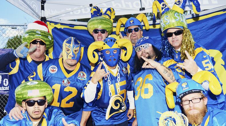 **EMBARGO: No electronic distribution, Web posting or street sales before FRIDAY 3 a.m. ET JAN. 5, 2018. No exceptions for any reasons. EMBARGO set by source.** Dave Stanley, top right, who is part of a group of die-hard Los Angeles Rams fans who wear hollowed-out watermelons on their heads when they sit in a section at the Los Angeles Memorial Coliseum known as the Melon Patch, with fellow fans in Los Angeles, Dec. 24, 2017. A new stadium is under construction for the Rams and Los Angeles Chargers in Inglewood. (Jake Michaels/The New York Times)