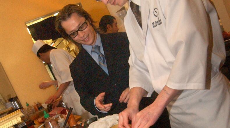 Alex (left) and Chris Kinjo work in 2004 at their first Atlanta restaurant, MF Sushibar. NICK ARROYO / AJC file MF Sushibar owners Alex and Chris Kinjo, (Photo taken Wednesday, February 25, 2004. by NICK ARROYO/AJC staff)