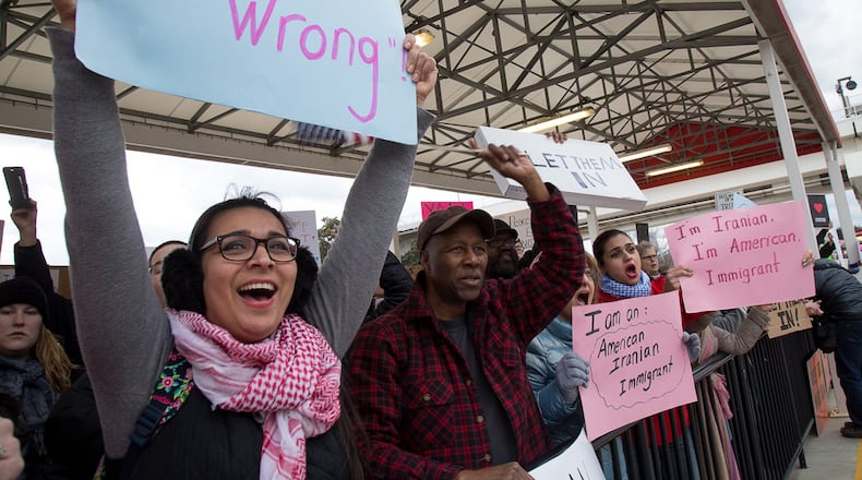 Protesters hold up signs during a demonstration against President Trump’s recent travel ban Sunday at Hartsfield-Jackson Atlanta International Airport January 30, 2017. STEVE SCHAEFER / SPECIAL TO THE AJC