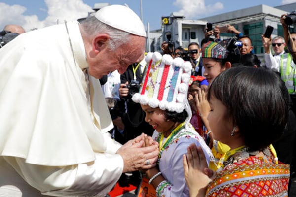 FILE - Pope Francis is greeted by young children in traditional clothes upon his arrival at Yangon's airport, Myanmar, Monday, Nov. 27, 2017. (AP Photo/Andrew Medichini, file)
