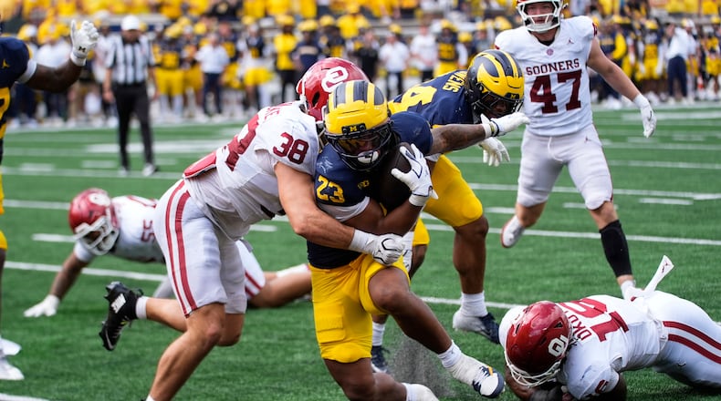 Michigan running back Jordan Marshall (23) scores a one-yard touchdown as Oklahoma linebacker Owen Heinecke (38) defends in the second half of an NCAA college football game Saturday, Sept. 12, 2026, in Ann Arbor, Mich. (AP Photo/Paul Sancya)