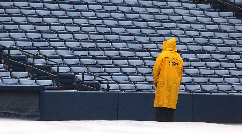 A security guard waits out a rain delay at Turner Field for the Braves against the Padres Thursday, June 11, 2015, in Atlanta.