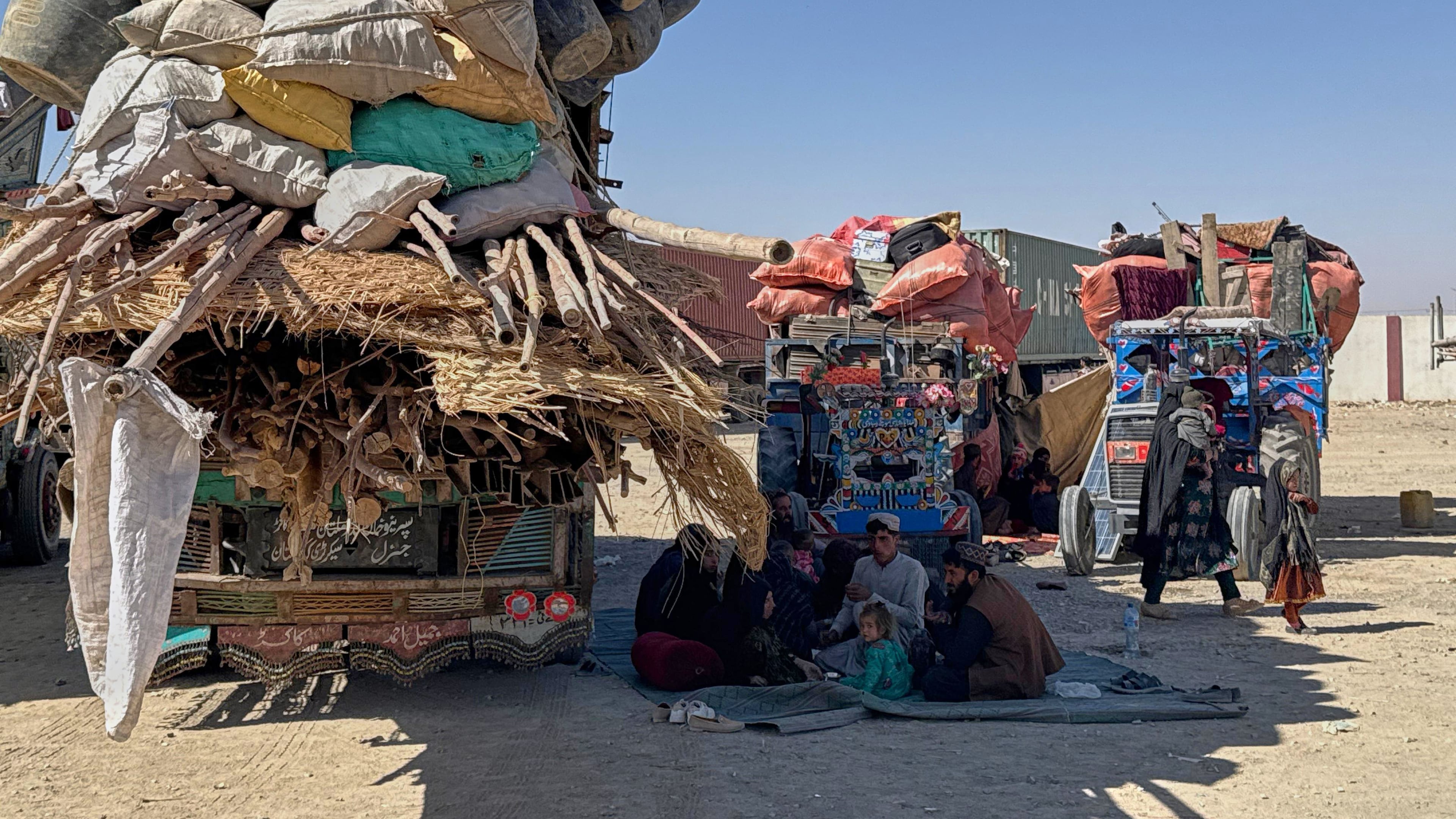 Afghan refugees sit next to their belongings loaded onto vehicles as they wait for opening of the border crossing point, which closed following Afghan and Pakistani security forces exchanged cross border firing, at a camp in Chaman, Pakistan, Sunday, Oct. 12, 2025. (AP Photo)