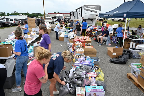 Volunteers sort food and clothing for distribution at the command center at the London-Corbin Airport in London, Ky., Monday, May 19, 2025. (AP Photo/Timothy D. Easley)