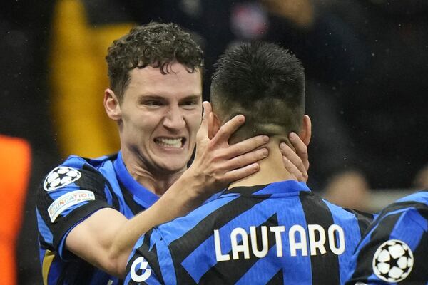Inter Milan's Benjamin Pavard, left, celebrates with his teammate Lautaro Martinez after scoring his side's second goal during the Champions League quarterfinal second leg soccer match between Inter Milan and Bayern Munich at the San Siro stadium in Milan, Italy, Wednesday, April 16, 2025. (AP Photo/Luca Bruno)