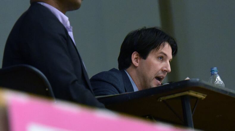 Scott Harris, Treasurer, speaks as Kaseem Ladipo (left), school board chairman, listens during a board meeting at Latin Academy Charter School earlier this year. HYOSUB SHIN / HSHIN@AJC.COM
