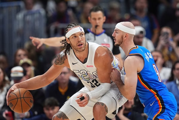 Denver Nuggets forward Aaron Gordon, left, looks to pass the ball as Oklahoma City Thunder guard Alex Caruso defends in the second half of Game 6 in the Western Conference semifinals of the NBA basketball playoffs Thursday, May 15, 2025, in Denver. (AP Photo/David Zalubowski)