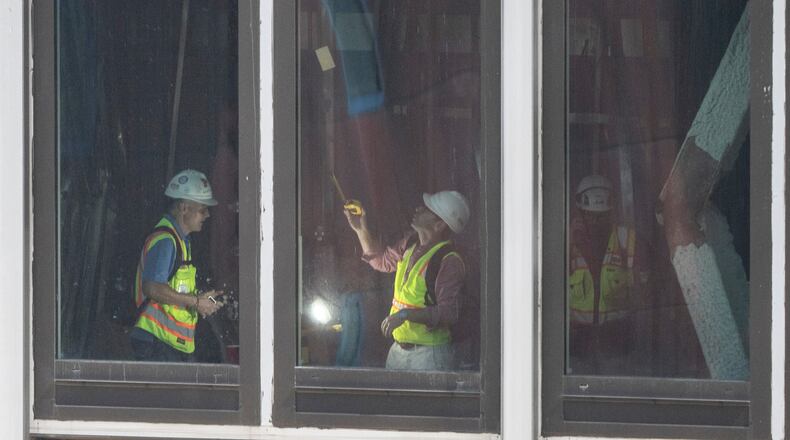 People inspect a buckled support beam inside 235 East 42nd Street, Wednesday, July 8, 2026, in New York. (AP Photo/Yuki Iwamura)