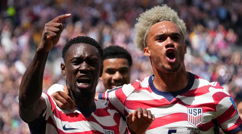 United States' Folarin Balogun (20) and Antonee Robinson (5) celebrate after scoring during the World Cup Group D soccer match between the United States and Australia in Seattle, Friday, June 19, 2026. (AP Photo/Ted S. Warren)