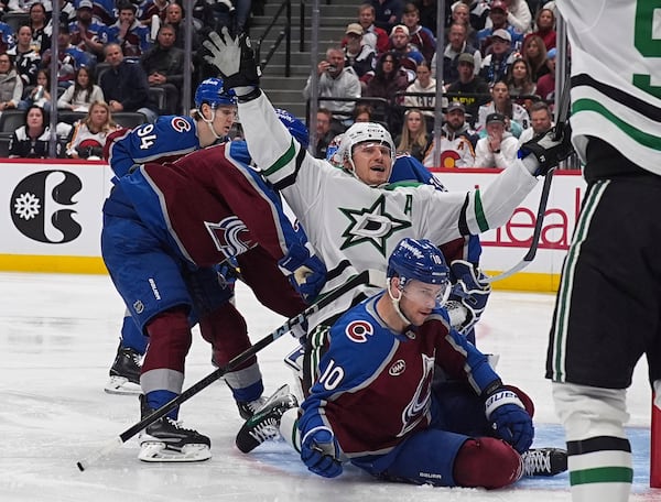 Dallas Stars center Roope Hintz, center top, celebrates after driving past Colorado Avalanche defenseman Ryan Lindgren, front left, and center Charlie Coyle (10) to score in the second period of Game 6 of an NHL hockey first-round playoff series Thursday, May 1, 2025, in Denver. (AP Photo/David Zalubowski)