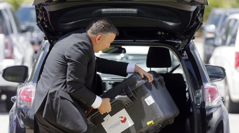 Grovetown - Scott Tucker from Dominion Voting unloads equipment for his presentation. BOB ANDRES /BANDRES@AJC.COM
