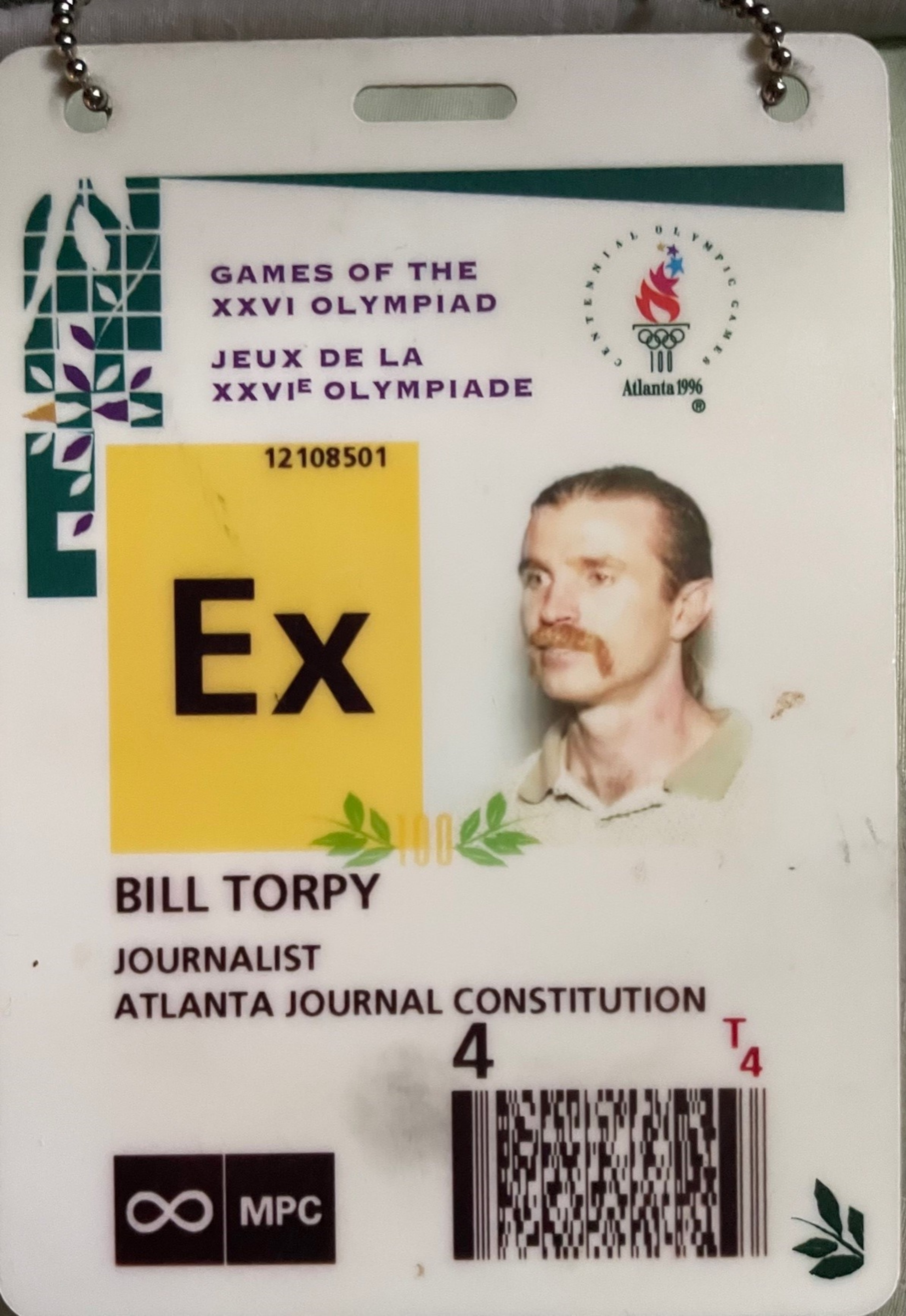 AJC columnist Bill Torpy's badge for the 1996 Olympic Games in Atlanta. He figured looking crazy with a ponytail and Fu Manchu 'stache might keep editors at bay. (Courtesy of Bill Torpy)
