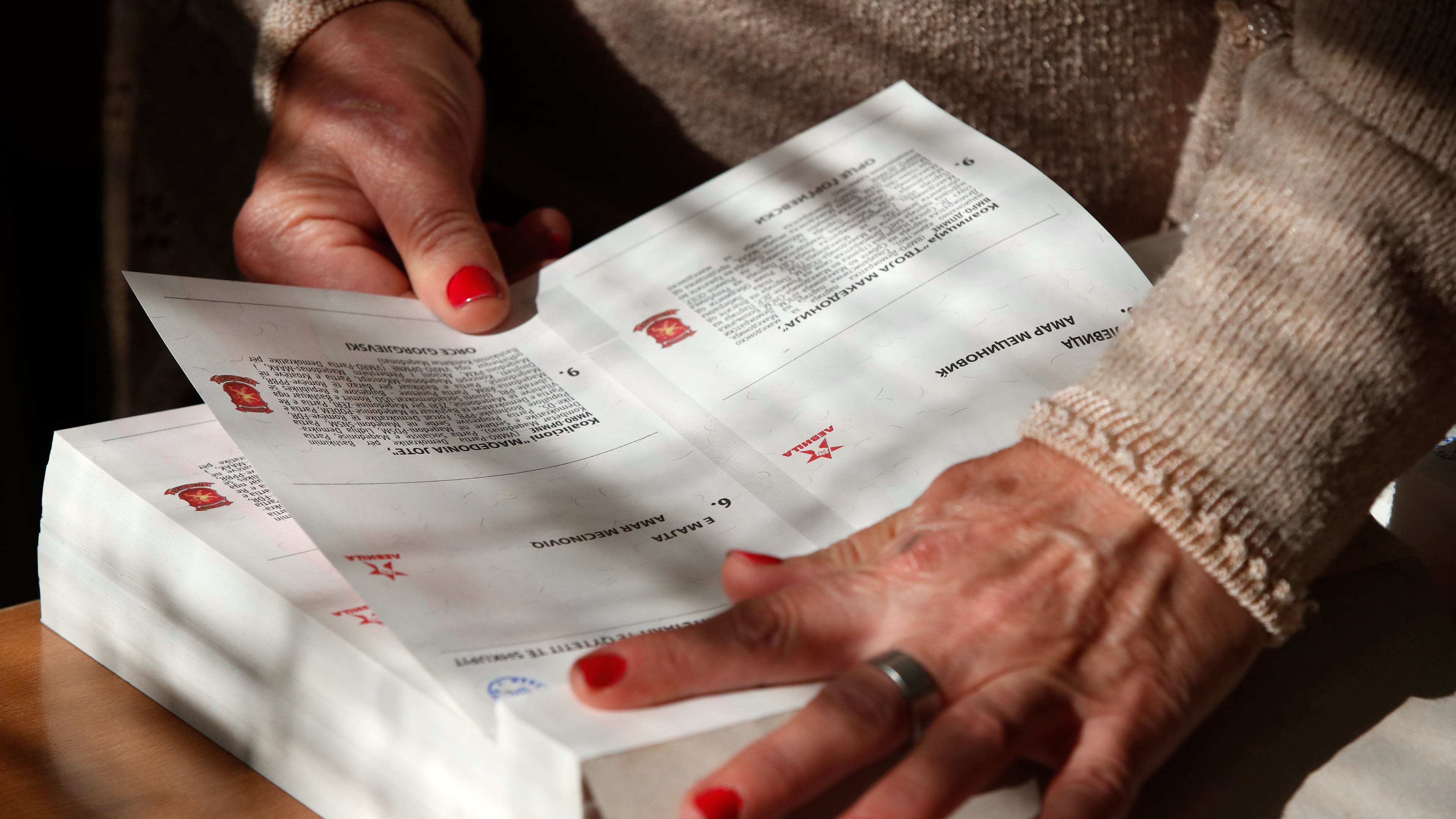 A member of the electoral commission prepares a ballot for voting in the runoff local elections, at a polling station in Skopje, North Macedonia, on Sunday, Nov. 2, 2025. (AP Photo/Boris Grdanoski)