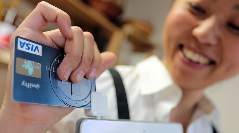 Fumiko Yajima, owner of her vegetable store Suika, swipes a credit card on her Apple Inc. iPad equipped with aa Square credit card-reader at her store in this arranged photograph taken in Tokyo, Japan, on Thursday, Oct. 10, 2013. Consumers in Japan paid cash for about 56 percent of their 279 trillion yen of purchases last fiscal year, while 12 percent was paid with plastic, Tokyo-based card company Credit Saison Co. estimates. Photographer: Yuriko Nakao/Bloomberg *** Local Caption *** Fumiko Yajima