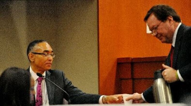 Burrell Ellis gets a drink of water from defense attorney Craig Gillen as he continues his testimony for a second day Friday. KENT D. JOHNSON /KDJOHNSON@AJC.COM