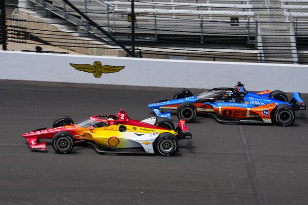 Josef Newgarden (2) and Graham Rahal drive into the first turn during practice for the Indianapolis 500 auto race at the Indianapolis Motor Speedway in Indianapolis, Monday, May 19, 2025. (AP Photo/Michael Conroy)