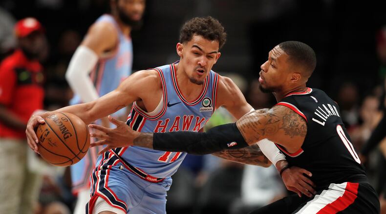 Hawks guard Trae Young (left) works against Portland Trail Blazers guard Damian Lillard. (AP Photo/John Bazemore)