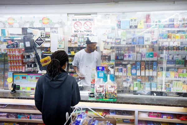 Store clerk Connell Daniels Jr. works the overnight shift at JJ Food Mart on Atlanta's west side. (Miguel Martinez/AJC)