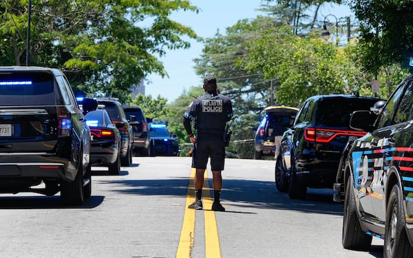 An Atlanta police officer stands in the middle of Montgomery Ferry Drive in northeast Atlanta as a large police presence gathers near the Beltline after a person was stabbed Thursday. (Ben Hendren for the AJC)
