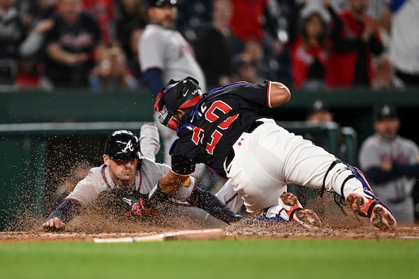 Atlanta Braves' Austin Riley is tagged out by Washington Nationals catcher Keibert Ruiz (20) as he attempts to score a run after a double hit by Matt Olson against pitcher Kyle Finnegan during the ninth inning of a baseball game in Washington, Thursday, May 22, 2025. (AP Photo/Terrance Williams)