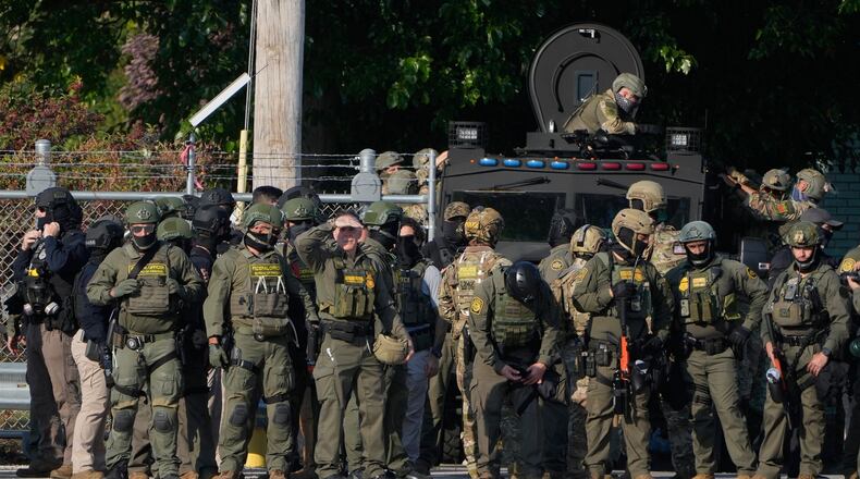 FILE - Greg Bovino, the chief patrol agent for the U.S. Border Patrol El Centro sector, center, stands with federal immigration agents near an Immigration and Customs Enforcement facility in Broadview, Ill., Oct. 3, 2025. (AP Photo/Erin Hooley, File)