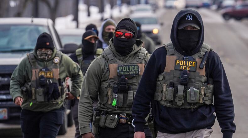 FILE - Federal agents walk down a street while conducting immigration enforcement operations in Minneapolis, Feb. 5, 2026. (AP Photo/Ryan Murphy, File)