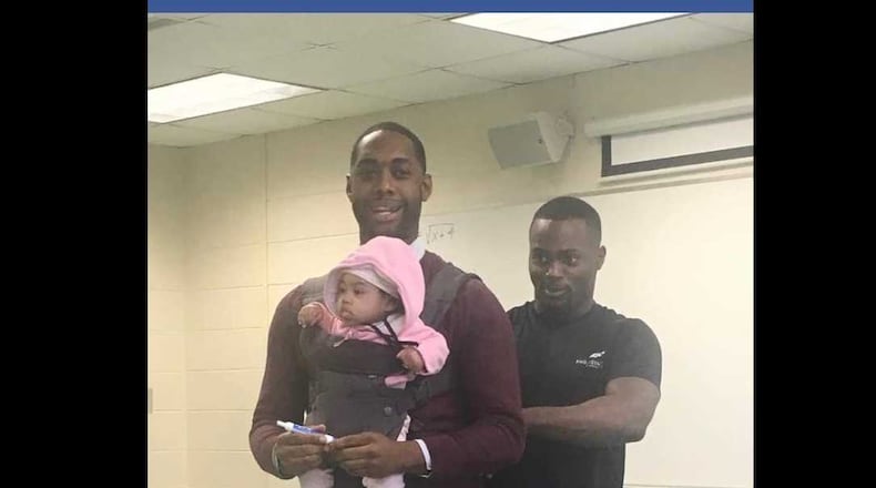 Morehouse College visiting professor Nathan Alexander volunteered to watch the child he's holding when his student, Wayne Hayer, right, could not find childcare before Alexander's class on Friday, March 1, 2019. PHOTO CONTRIBUTED.