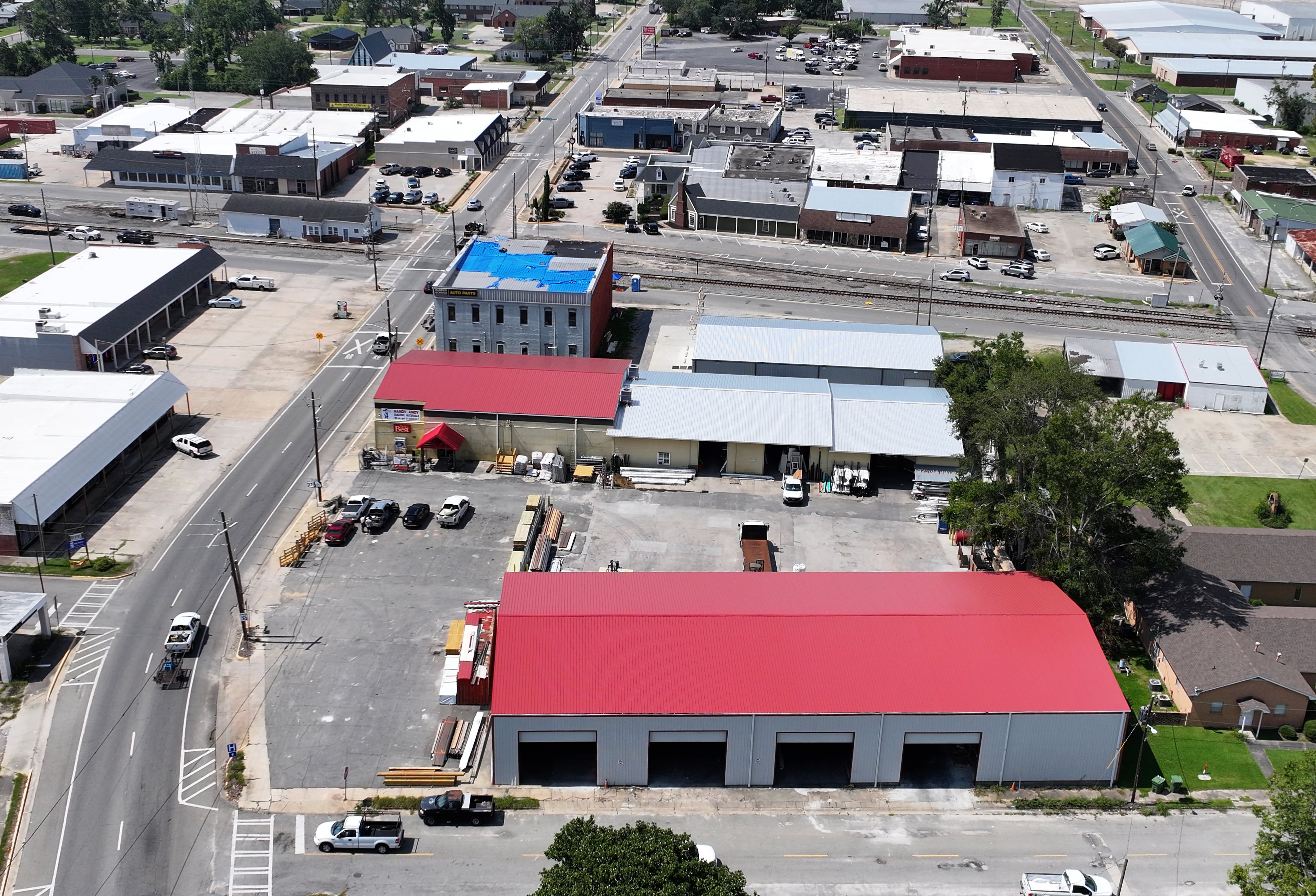 The damage from Hurricane Helene has been repaired in some places in downtown Hazlehurst — the red roofs are new — however blue tarps remain on some roofs nearly a year after the storm. (Hyosub Shin/AJC)