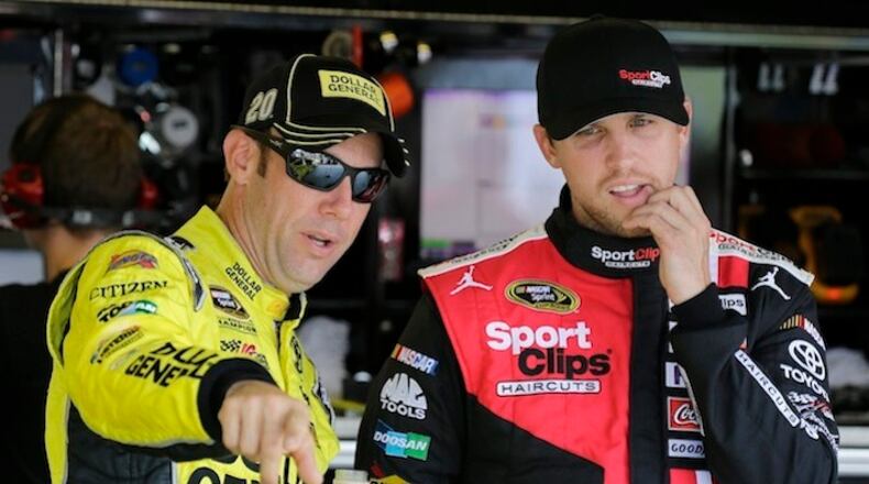 Matt Kenseth, left, points out something to Denny Hamlin before a NASCAR Sprint Cup practice session at Darlington Raceway in Darlington, S.C., Friday, Sept. 4, 2015. (AP Photo/Terry Renna)