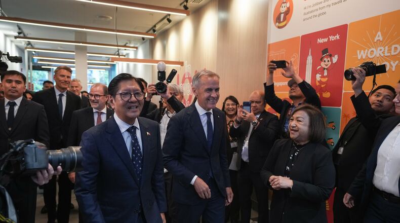 Canada's Prime Minister Mark Carney, center, and Philippines President Ferdinand Marcos Jr., right, arrive for a visit to a Jollibee fast food restaurant, in Vancouver, Thursday, July 2, 2026. (Darryl Dyck/The Canadian Press via AP)