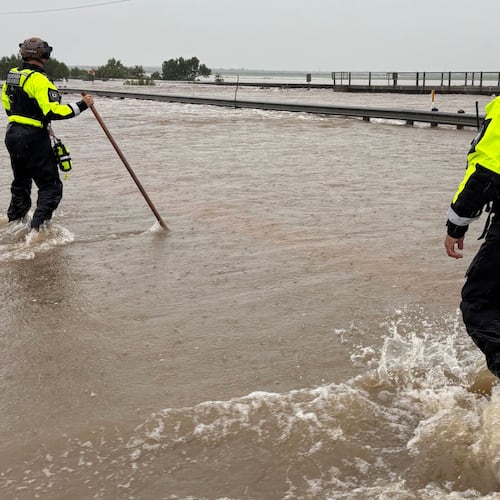 In this handout photo provided by the Texas Parks and Wildlife Department, game wardens walk through high waters from heavy rains in Uvalde County, Texas, on Tuesday, July 14, 2026. (Texas Parks and Wildlife Department via AP)