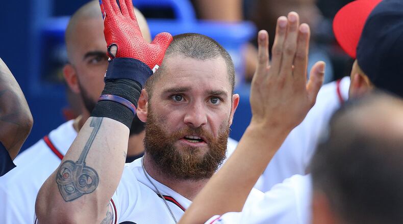 Braves’ Jonny Gomes gets high-fives in the dugout after hitting a two-run home run to take a 2-1 lead over the Rockies at Turner Field on Monday, Aug. 24, 2015, in Atlanta. (Curtis Compton/ccompton@ajc.com)