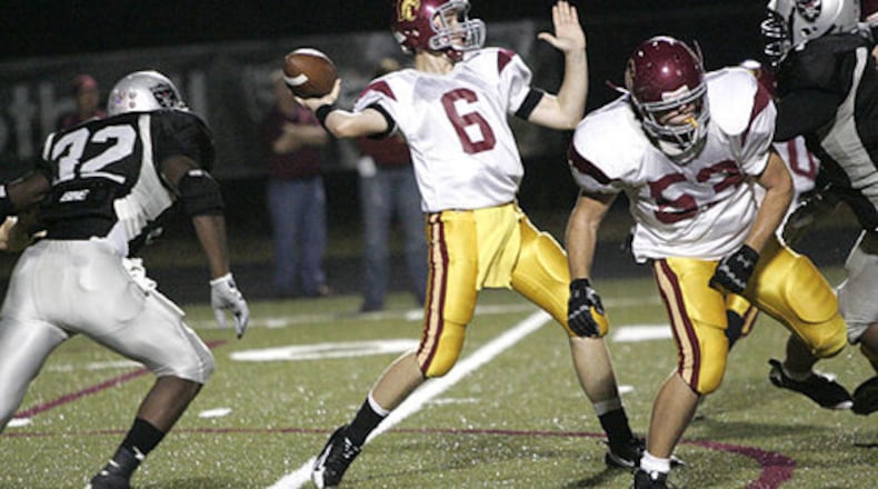 Lassiter QB Hutson Mason (6) drops back to pass while Alpharetta LB George Osunde (left) defends and Lassiter OL J.D. Daily (53) blocks.