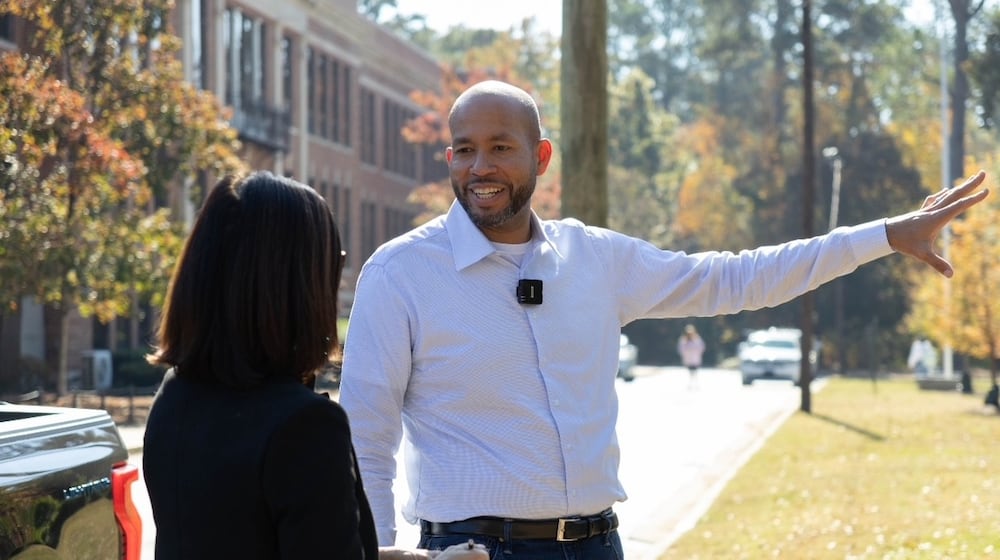 Former state Sen. Jason Esteves' Democratic campaign for governor is focused on economic opportunity. He said attending North Columbus High School (in background) opened opportunities that friends at other Columbus schools did not have. (Anna Girzone for the AJC)