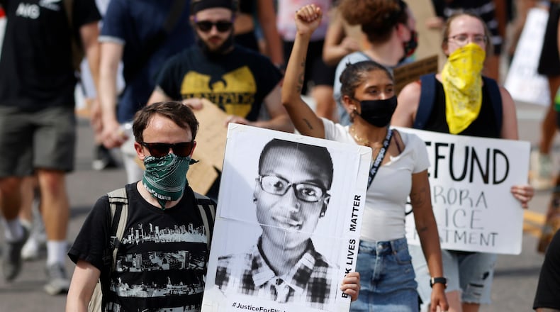 FILE - A demonstrator carries an image of Elijah McClain during a rally and march, June 27, 2020, in Aurora, Colo. Two paramedics were convicted Friday, Dec. 22, 2023, in the 2019 killing of McClain, who they injected with an overdose of the sedative ketamine after police put him in a neck hold. (AP Photo/David Zalubowski, File)