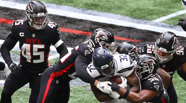 091320 Atlanta: Atlanta Falcons defenders Deion Jones (from left), Isaiah Oliver, Dante Fowler, and Tyeler Davison gang tackle Seattle Seahawks running back Chris Carson in a NFL football game on Sunday, Sept. 13, 2020 in Atlanta.   ���Curtis Compton / Curtis.Compton@ajc.com���