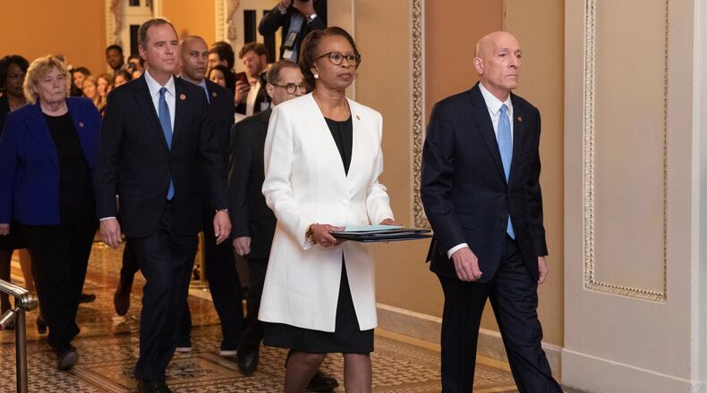 House Sergeant at Arms Paul Irving and Clerk of the House Cheryl Johnson carry the articles of impeachment against President Donald Trump to Secretary of the Senate Julie Adams on Capitol Hill in Washington, Wednesday, Jan. 15, 2020. Following are impeachment managers, House Judiciary Committee Chairman, Rep. Jerrold Nadler, D-N.Y., House Intelligence Committee Chairman Adam Schiff, D-Calif., Rep. Hakeem Jeffries, D-N.Y., Rep. Sylvia Garcia, D-Texas, Rep. Val Demings, D-Fla., Rep. Zoe Lofgren, D-Calif., and Rep. Jason Crow, D-Colo. (AP Photo/Manuel Balce Ceneta)