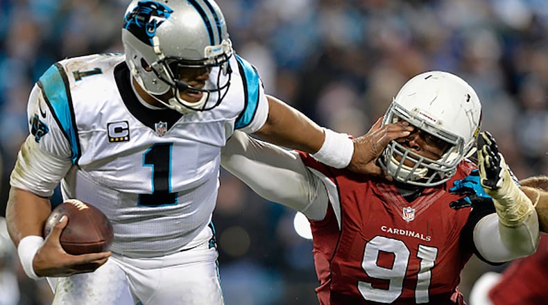 CHARLOTTE, NC - JANUARY 24: Cam Newton #1 of the Carolina Panthers stiff arms Ed Stinson #91 of the Arizona Cardinals in the second half during the NFC Championship Game at Bank of America Stadium on January 24, 2016 in Charlotte, North Carolina. (Photo by Grant Halverson/Getty Images)