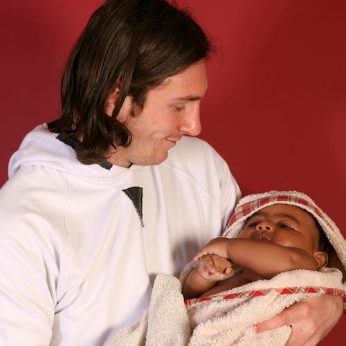 20-year-old soccer star Lionel Messi cradles Lamine Yamal, who was merely six months old at the time during a photo session in Sept. 2007 in the dressing room of the Camp Nou stadium in Barcelona, Spain. (AP Photo/Joan Monfort)