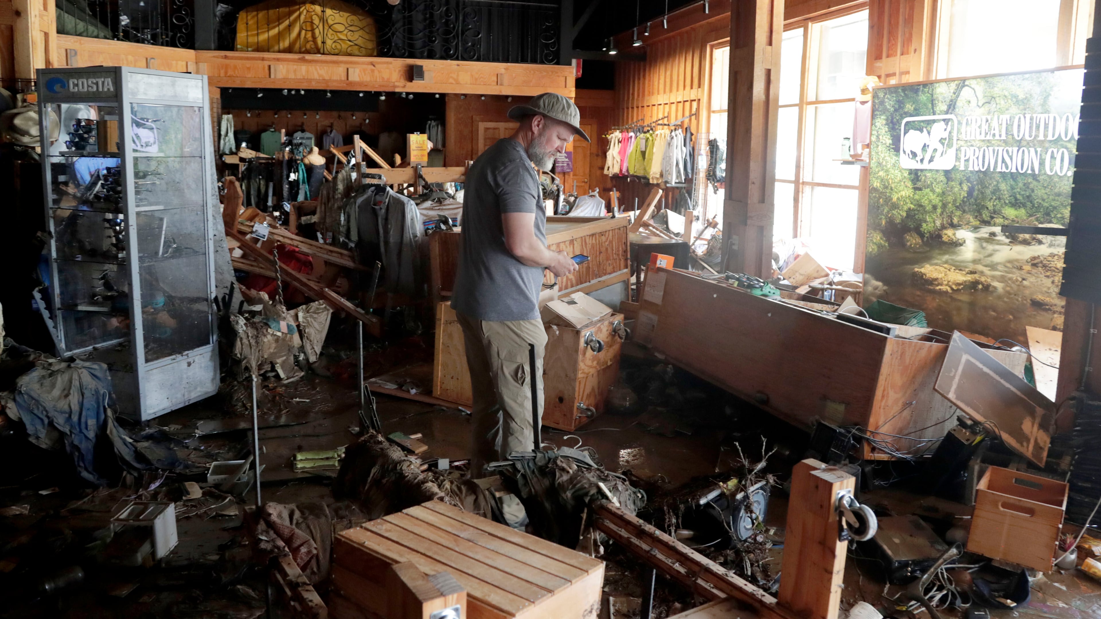 FILE - An employee surveys the damage at the Great Outdoor Provision Co. after it was flooded during tropical storm Chantal, Monday, July 7, 28, 2025, in Chapel Hill, N.C. (AP Photo/Chris Seward, file)