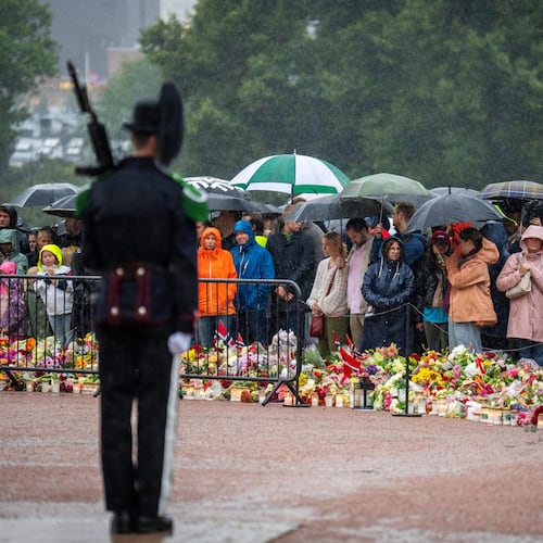 Mourners gather in the pouring rain to watch as King Harald V's remains arrive to the Royal Palace in Oslo, Norway, Friday, Aug. 28, 2026. (Heiko Junge/NTB via AP)