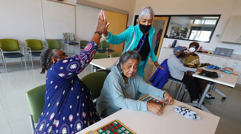 022422 Snellville: Bertha Flowers (left) gets five from Rose Golson after hitting bingo while playing at the Centerville Senior Center on Thursday, Feb. 24, 2022, in Snellville. Gwinnett County is expanding its Health and Human Services department and a future expansion will connect the senior center with another building. “Curtis Compton / Curtis.Compton@ajc.com”`