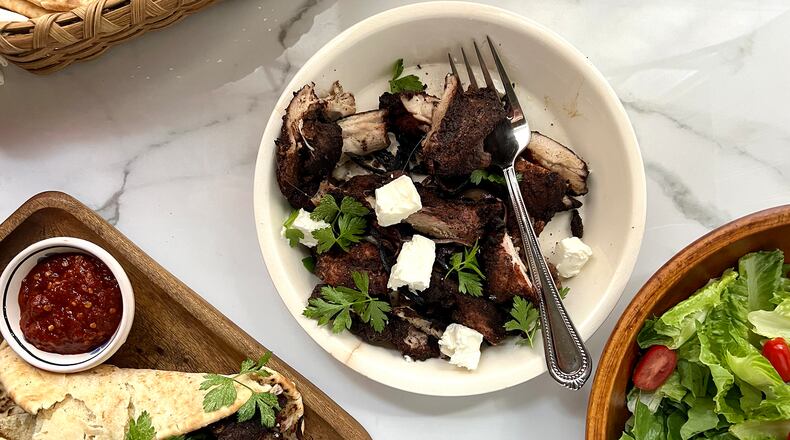 Shawarma-spiced chicken thighs with herbs and feta wrapped in pita bread and served with a side salad.
(Virginia Willis for The Atlanta Journal-Constitution)
