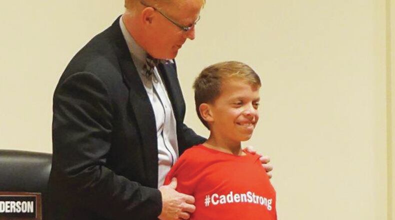Creekland Middle School sixth-grader Caden Cherry is welcomed onstage at the Cherokee County School Board meeting on Oct. 13 by school superintendent Dr. Brian Hightower. Caden experienced cardiac arrest at the school Sept. 29, and was resuscitated by school staff.