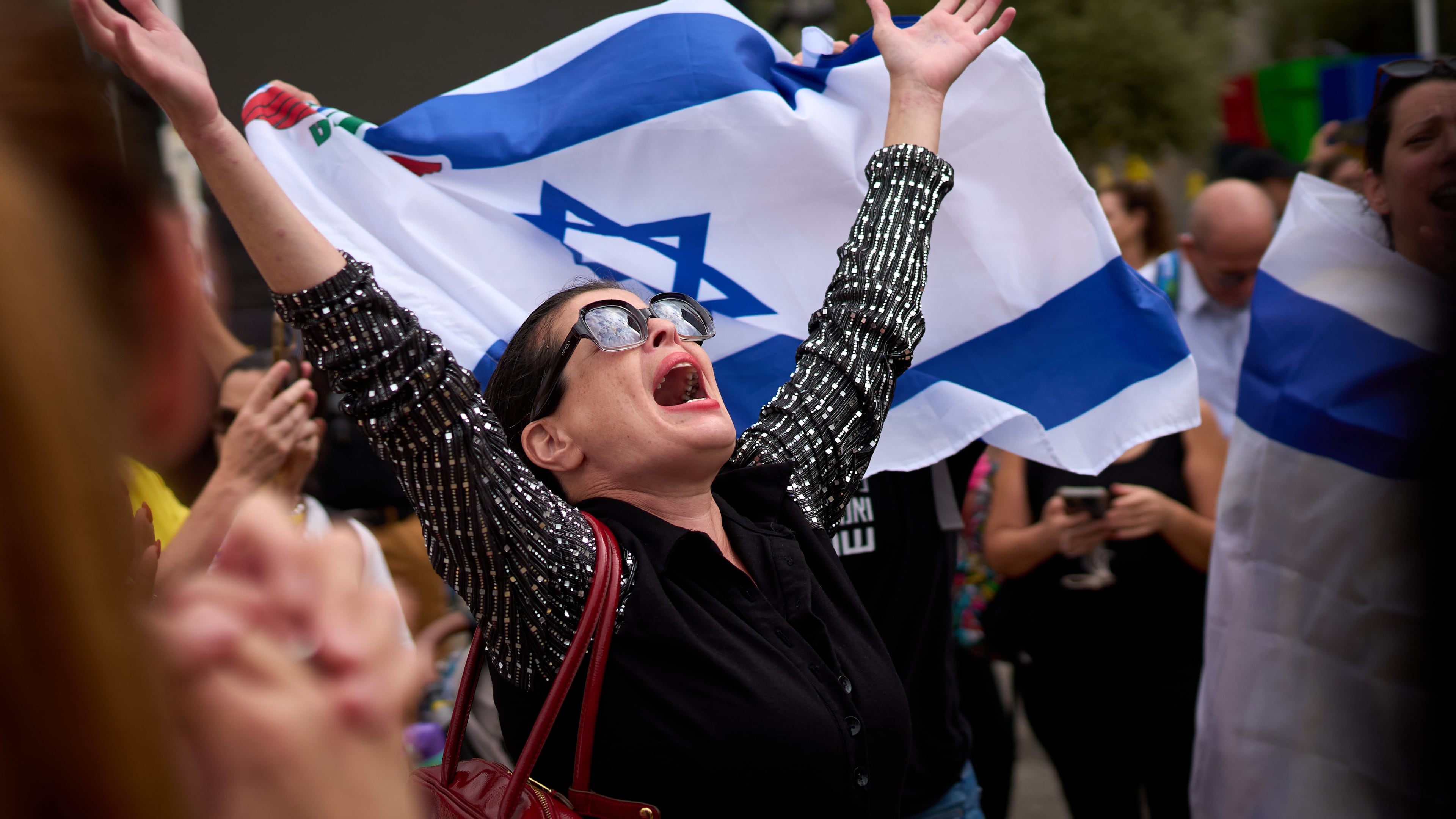 People react as they celebrate following the announcement that Israel and Hamas have agreed to the first phase of a peace plan to pause the fighting, at a plaza known as hostages square in Tel Aviv, Israel, Thursday, Oct. 9, 2025. (AP Photo/Emilio Morenatti)