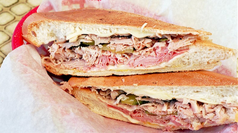 A cuban sandwich consisting fo ham roast pork swiss cheese and pickles on Cuban Bread from Havana Sandwich Shop