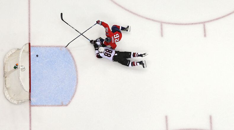 WASHINGTON, DC - MARCH 25: Daniel Winnik #26 of the Washington Capitals scores an empty net goal in front of Jamie McGinn #88 of the Arizona Coyotes during the third period at Verizon Center on March 25, 2017 in Washington, DC. The goal was his second goal of the third period.(Photo by Patrick Smith/Getty Images)