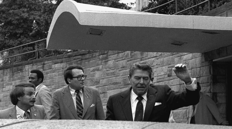 FILE - President Ronald Reagan winces and raises his left arm as he was shot by an assailant as he left a Washington hotel, Monday, March 30, 1981. (AP Photo/Ron Edmonds, File)