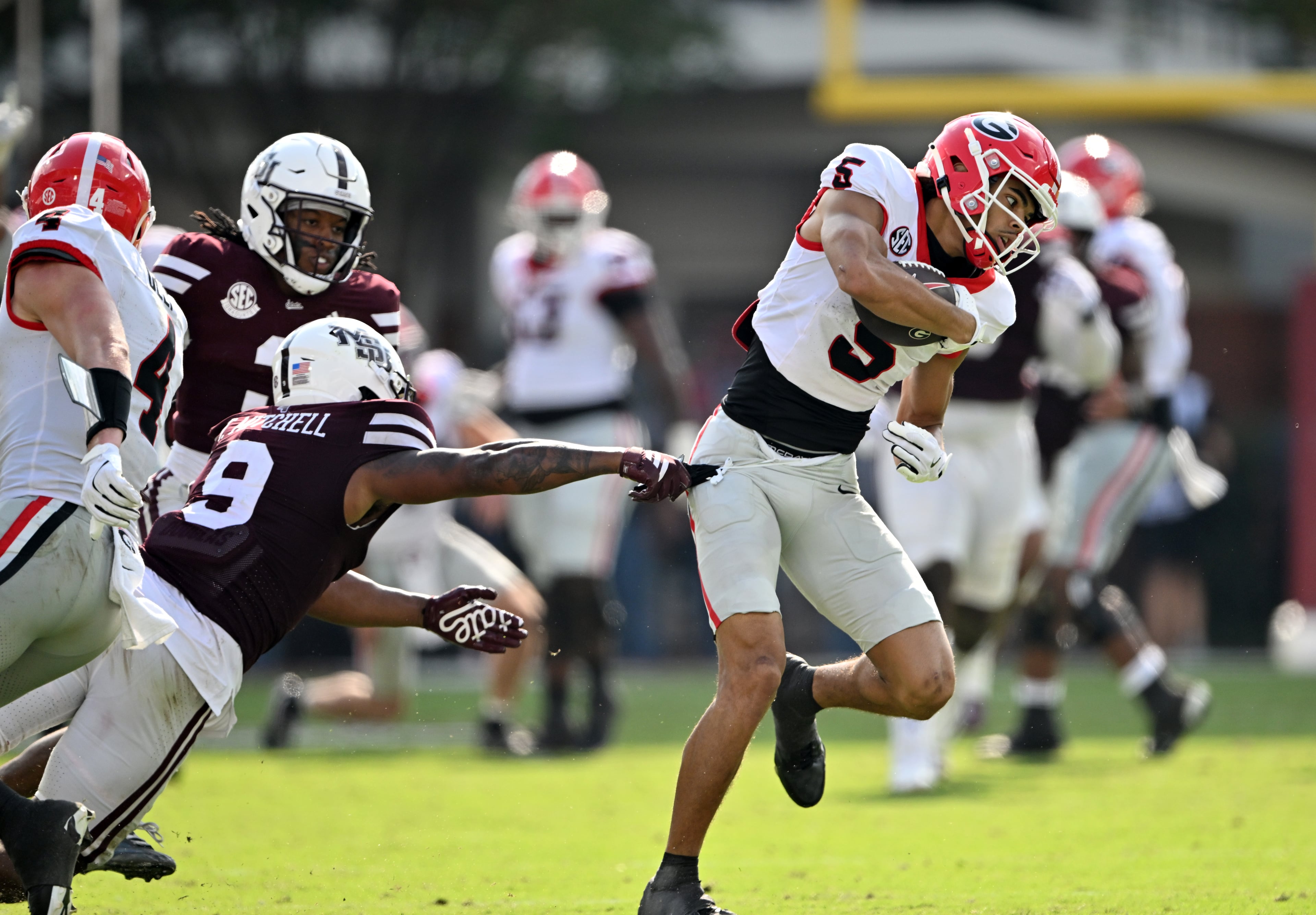 Georgia wide receiver Noah Thomas (5) eludes a tackle by Mississippi State safety Tony Mitchell (9) and runs for a touchdown during the second half in an NCAA football game at Davis Wade Stadium, Saturday, November 8, 2025, in Starkville, Mississippi. Georgia won 41-21 over Mississippi State. (Hyosub Shin / AJC)