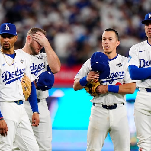 Los Angeles Dodgers shortstop Mookie Betts (50) third baseman Max Muncy (13) second baseman Tommy Edman (25) and first baseman Freddie Freeman (5) look on during a pitching change during seventh inning Game 5 World Series playoff MLB baseball action against the Toronto Blue Jays in Los Angeles on Wednesday, Oct. 29, 2025. (Frank Gunn/The Canadian Press via AP)